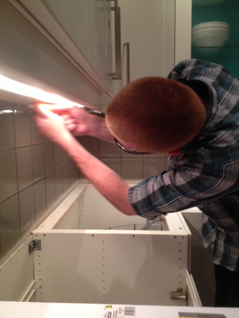Matt sawing the drywall under the cabinets